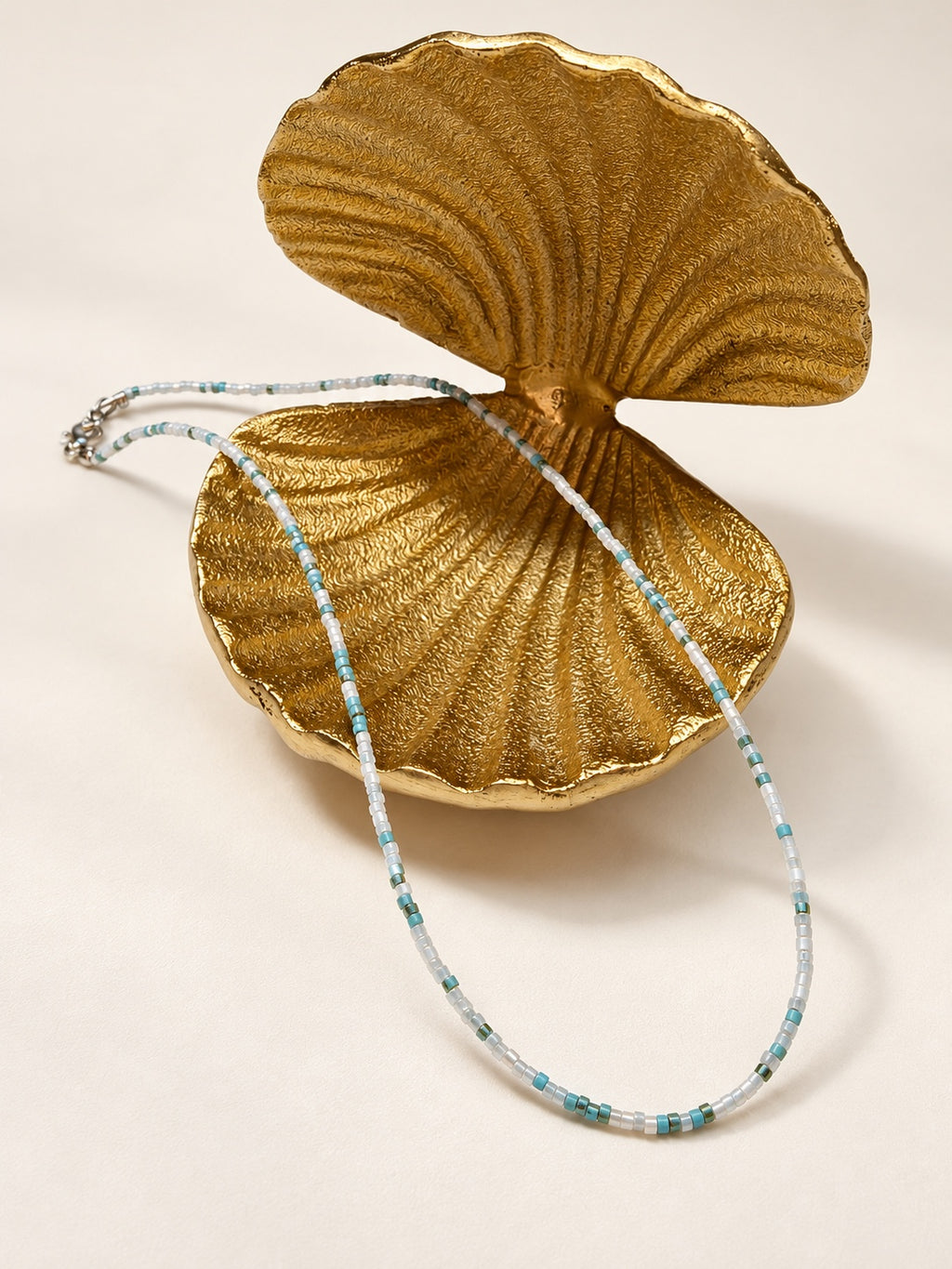 Waves Choker styled on a gold shell dish