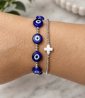 Blue evil eye bracelet shown beside a separate silver bead cross bracelet