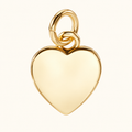Single polished gold-tone blank heart charm on off-white