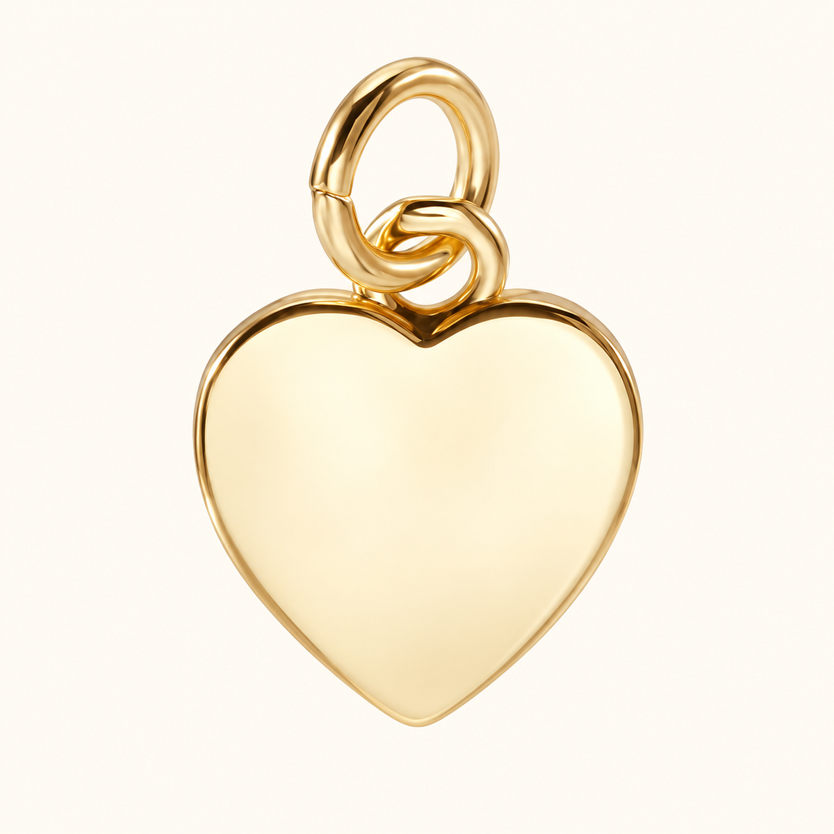 Single polished gold-tone blank heart charm on off-white