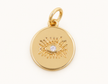 Single round gold-tone evil eye charm on off-white