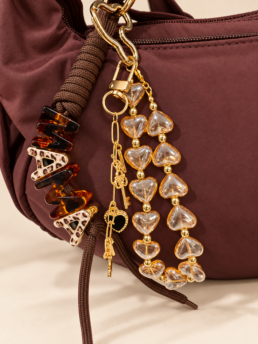 Brown bag with clear heart-bead bag charms and gold-tone hardware