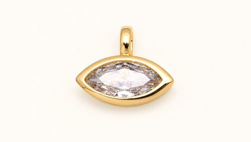 Single marquise-cut clear crystal charm in a gold-tone bezel on off-white