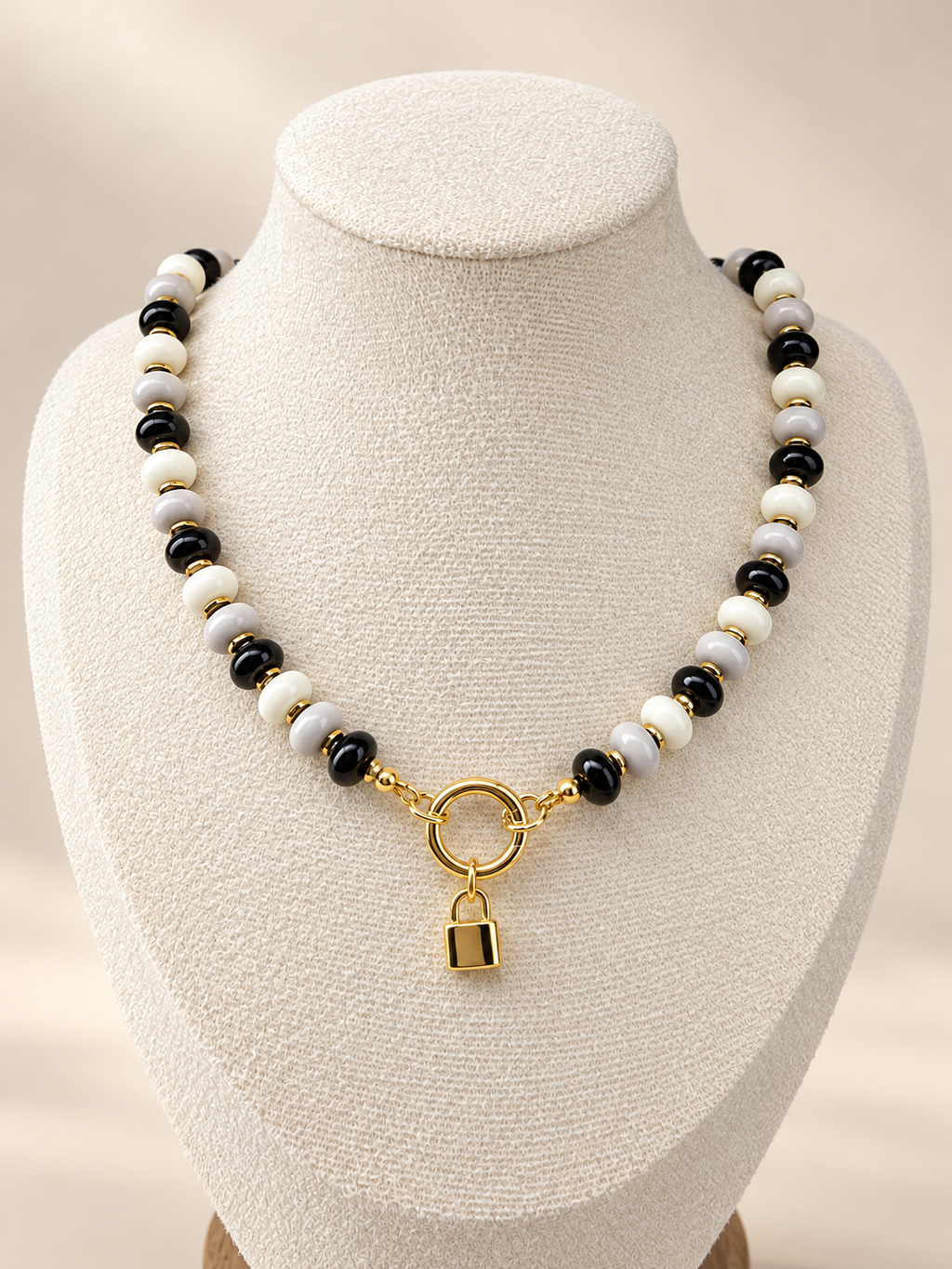 Midnight Muse Necklace displayed on a cream bust with a lock charm