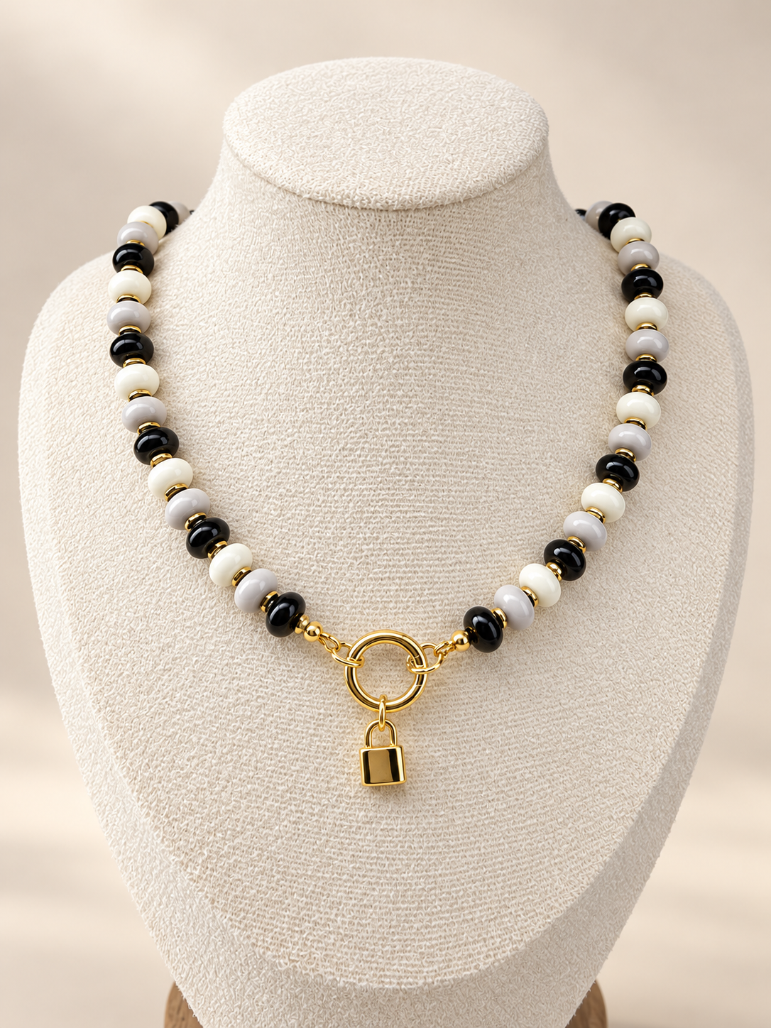 Midnight Muse Necklace displayed on a cream bust with a lock charm