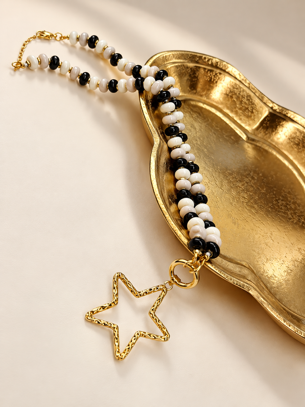 Midnight Muse Necklace on a gold dish