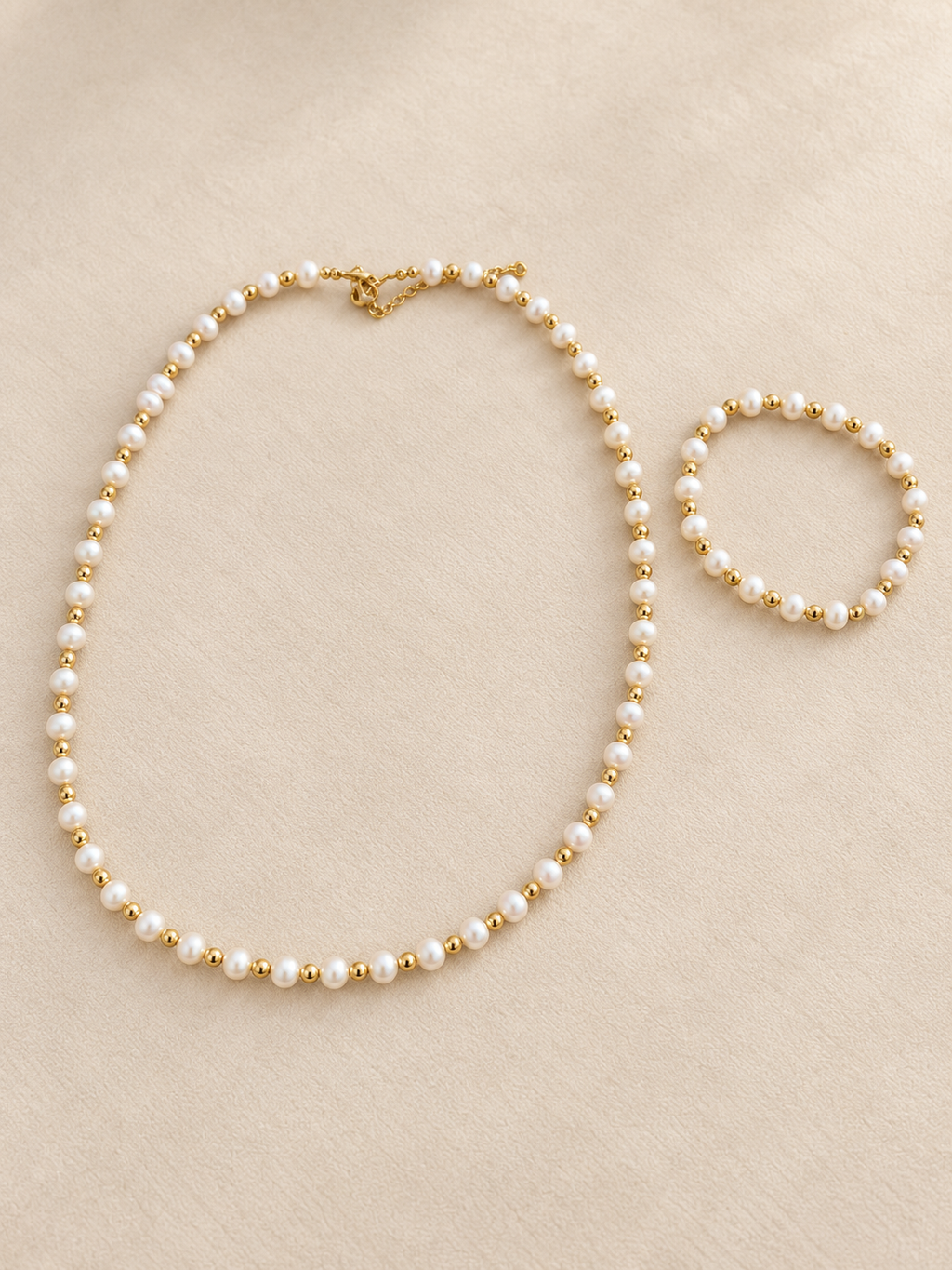 Pearl-style and gold-tone necklace with matching bracelet