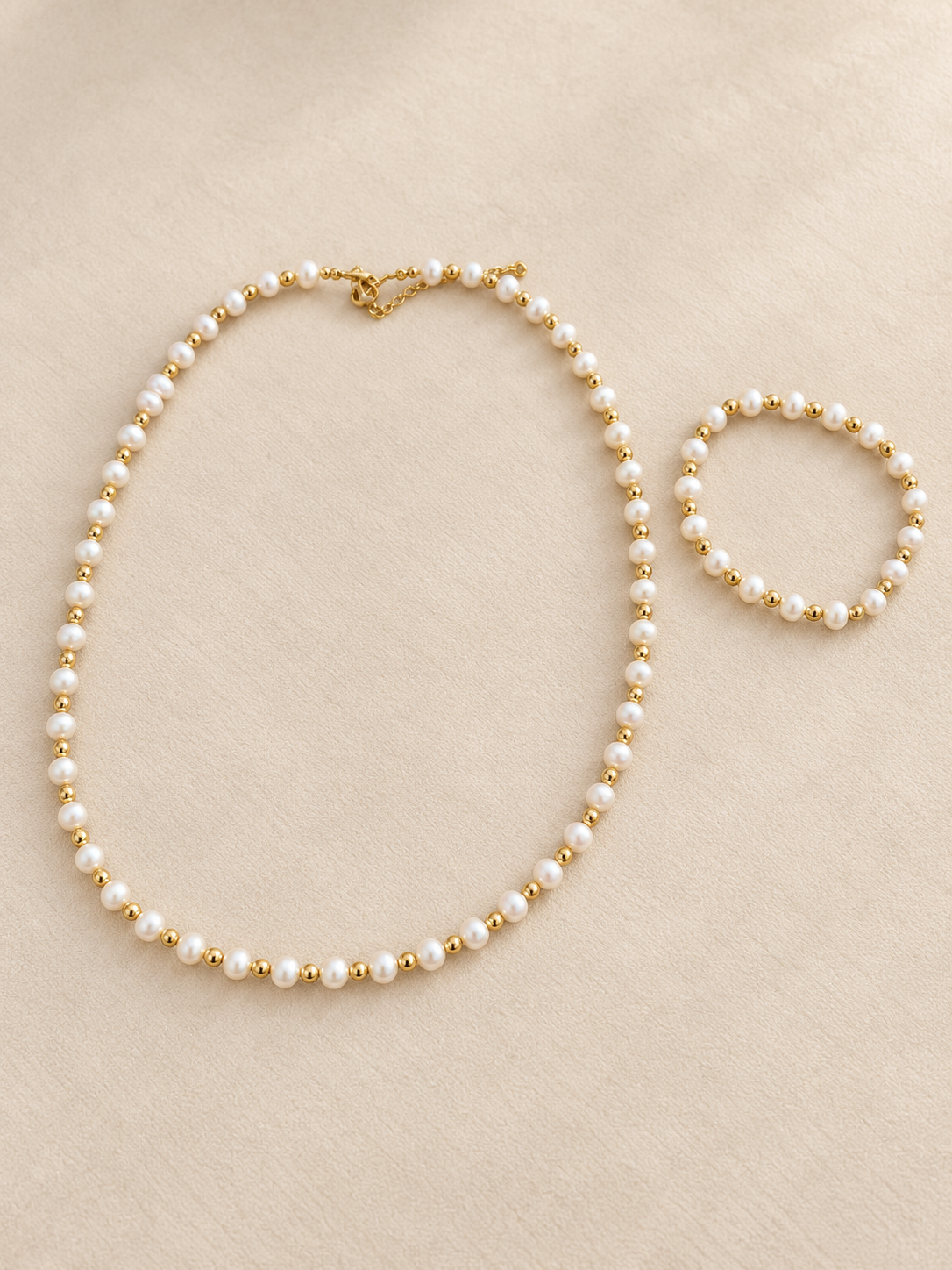 Pearl-style and gold-tone necklace with matching bracelet