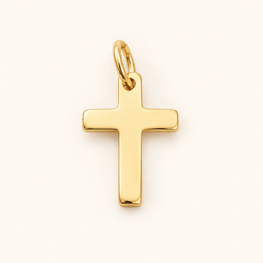 Single polished gold-tone cross charm on off-white