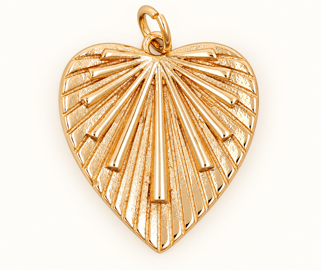Single gold-tone heart charm with radiating ridges on off-white