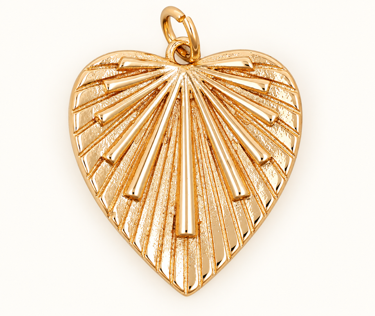 Single gold-tone heart charm with radiating ridges on off-white