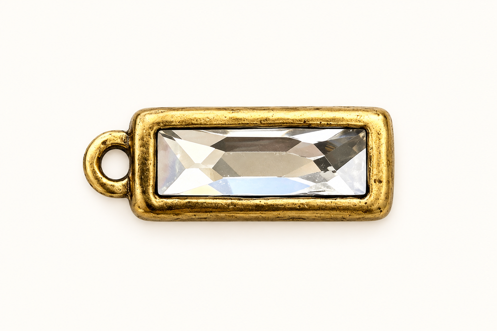 Single clear rectangular crystal charm in gold-tone bezel on off-white