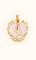 Single pale pink heart charm with gold-tone rose detail on off-white