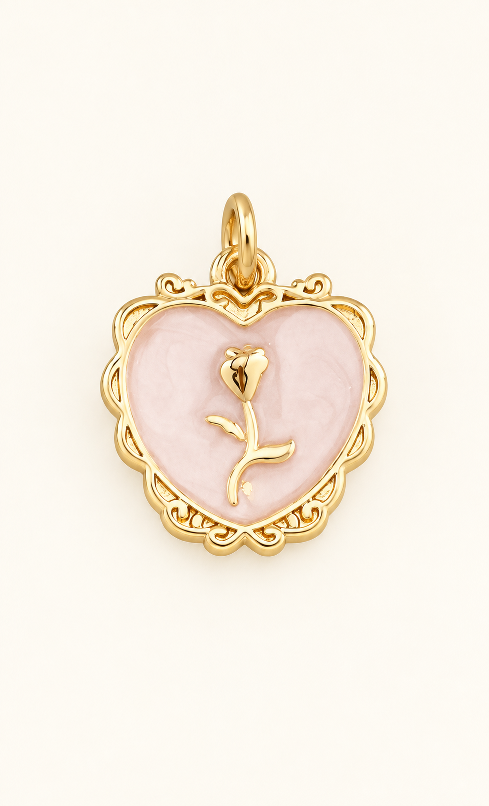 Single pale pink heart charm with gold-tone rose detail on off-white
