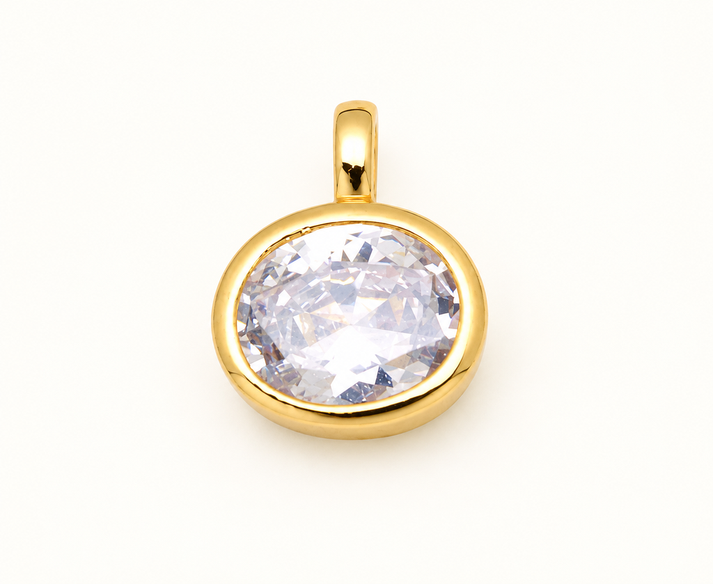 Single round clear crystal charm in a gold-tone bezel on off-white