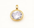 Single round clear crystal charm in a gold-tone bezel on off-white