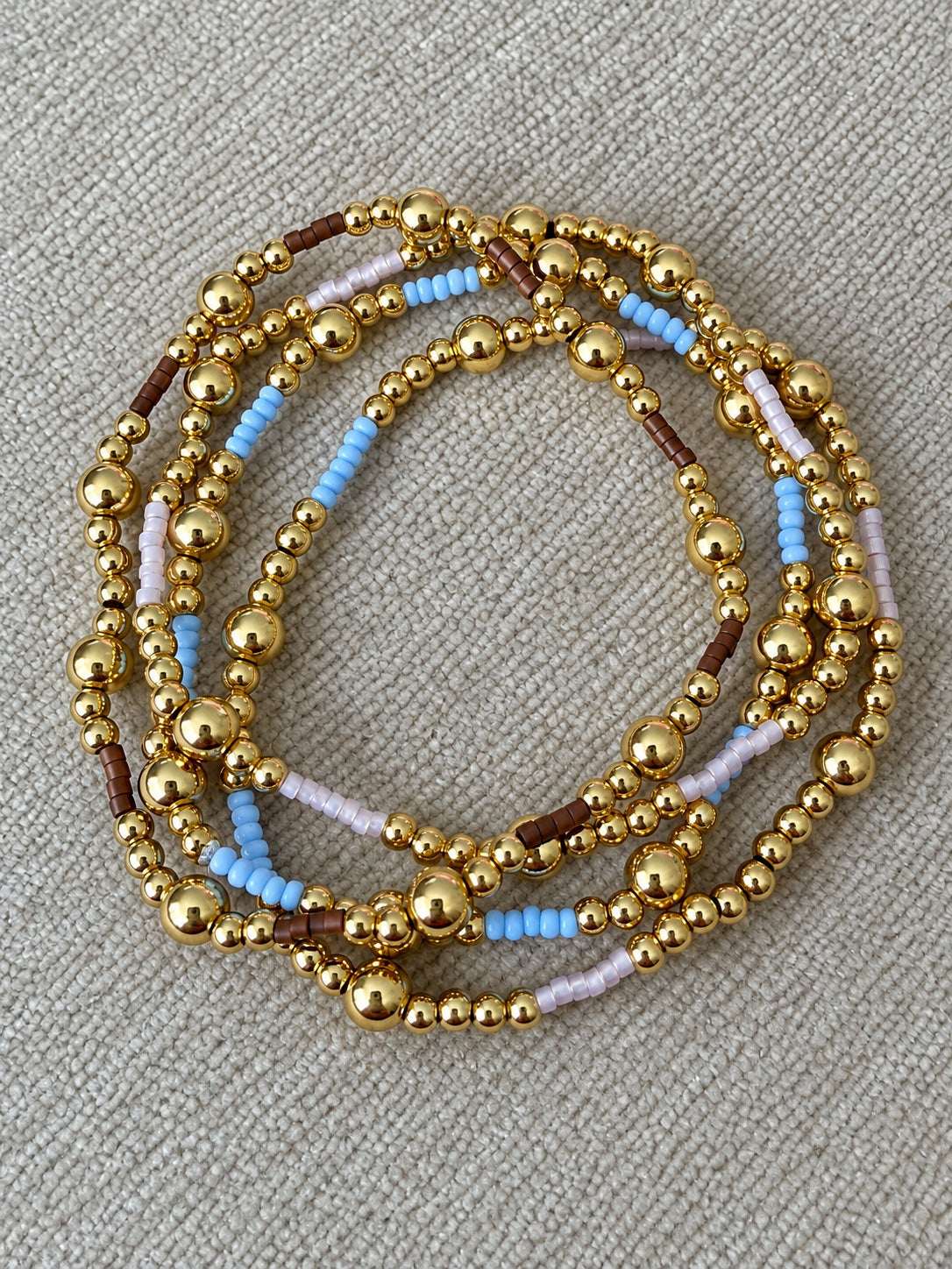 Sky, lilac, and mocha gold bead bracelets displayed together