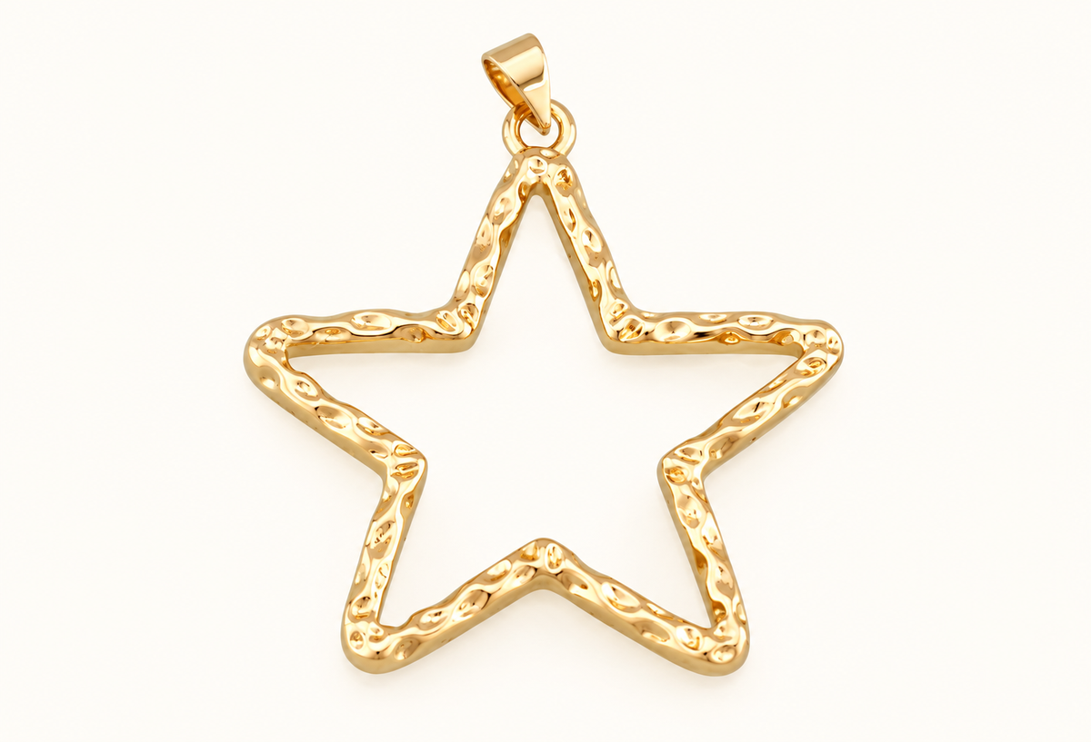 Single open gold-tone star charm on off-white
