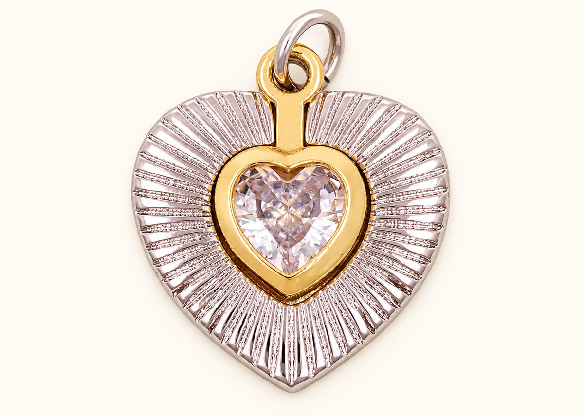 Single two-tone heart charm with a clear heart crystal on off-white